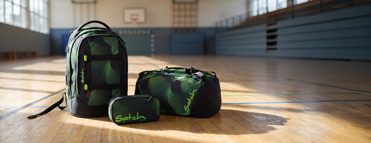 Schulrucksack Satch Pack Seismic Green auf dem Turnhallenboden